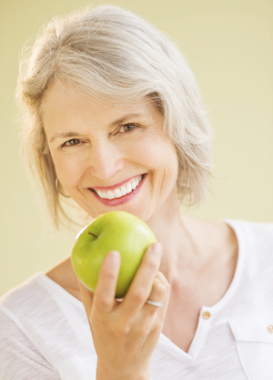 woman able to eat an apple after restorative dental treatment