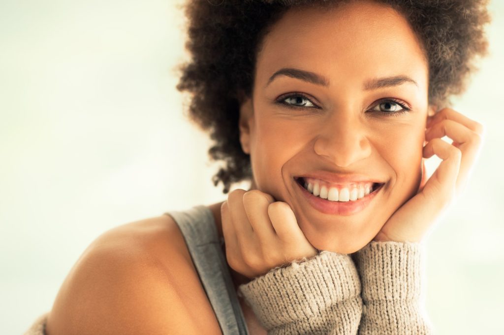 woman smiling while showing her new dental veneers