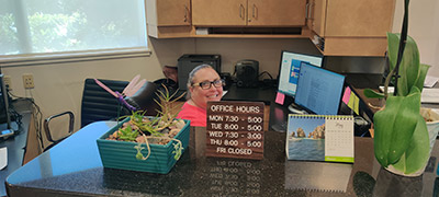 Woman at front desk smiling at Scott Hoffman, DDS